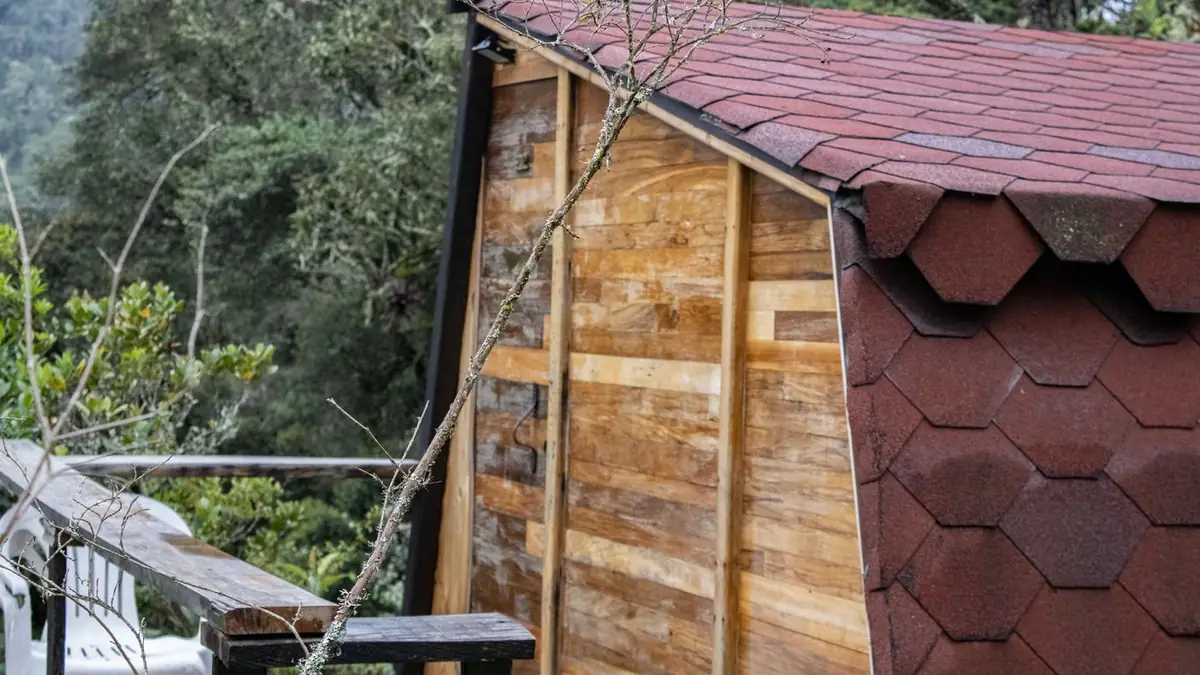 Cabin Bosque from the side, with its red shingle roof and wood walls