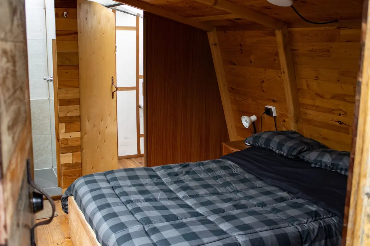 Bedroom in Cabin Bosque with a double bed and the bathroom behind